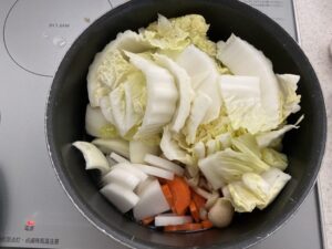 鍋に野菜を入れる